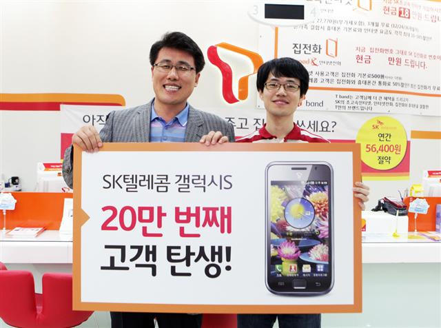 갤럭시S 20만번째 고객인 조현욱(오른쪽)씨가 지난 3일 서울 논현동 SK텔레콤 강남대리점에서 김선중 SK텔레콤 영업본부장과 함께 축하 패널을 들고 있다. SK텔레콤 제공