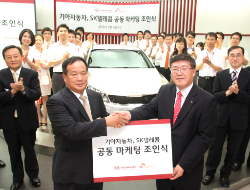 7일 서울 압구정동 기아자동차 국내영업본부 사옥에서 열린 공동 마케팅 조인식에서 박인식(오른쪽) SK텔레콤 기업사업부문장과 김충호 기아자동차 국내영업본부장이 양해각서를 교환한 뒤 기념촬영을 하고 있다. SK텔레콤 제공