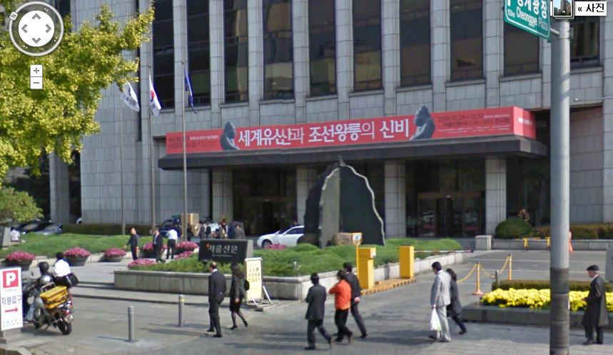 구글 스트리트뷰에 나타난 서울 태평로1가 서울신문사 입구. 건물 현관에 ‘세계유산과 조선왕릉의 신비’ 사진전 현수막이 걸려있는 것으로 미루어 2009년 말에 촬영된 것으로 추정된다. 사진을 찍을 당시 길을 지나던 사람들의 모습이 그대로 나타난다. 특수카메라 장착차량을 이용해 직접 촬영을 하기 때문에 원치 않는 개인 사생활 노출이 일어날 수 있다. <화면 캡처>