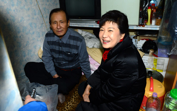 박근혜 대통령 당선인이 성탄절인 25일 서울 창신동 쪽방촌에서 직접 만든 도시락을 독거노인에게 전달한 뒤 대화를 나누고 있다. 연합뉴스