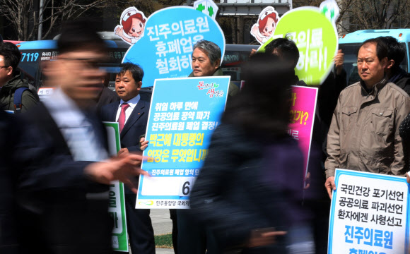진주의료원 휴·폐업 철회를 요구하며 단식 농성 중인 국회 보건복지위원회 소속 김용익(가운데·민주통합당) 의원이 9일 서울 광화문광장에서 피켓을 들고 시위하고 있다. 연합뉴스