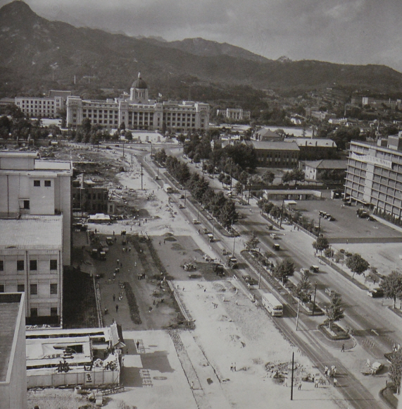 1960년대 초 세종로에서 도로 폭을 100m로 확장하는 공사가 진행되고 있다. 사진 왼쪽에 기존 건물을 헐어낸 표시가 뚜렷하다. 오른쪽 위는 옛 경기도청이며 다음 건물은 미국 자본 500만 달러의 원조와 필리핀 기술로 지어진 대한민국역사박물관이다. 서울시정 사진기록총서:서울역사박물관 제공