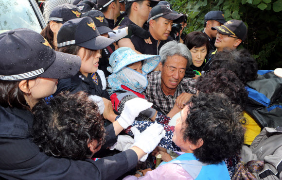 1일 오전 경남 밀양시 단장면 고례리 765㎸ 송전탑 공사현장 입구에서 공사 재개에 반대하는 고령의 주민들이 경찰과 몸싸움을 벌이고 있다. 이날 한전은 2일부터 밀양 송전탑 공사를 재개한다고 밝혔다. 밀양 연합뉴스