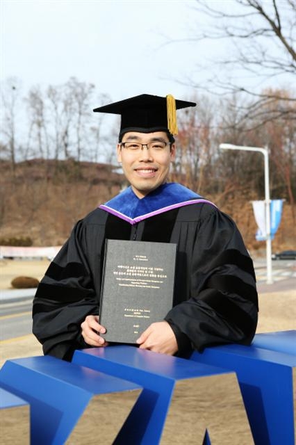 게임을 연구해 박사학위를 받고 미항공우주국(NASA)에서 근무하게 된 박태우씨가 20일 대전 유성구 대학로 카이스트 교정에서 박사논문을 들고 활짝 웃고 있다. 한국과학기술원 제공
