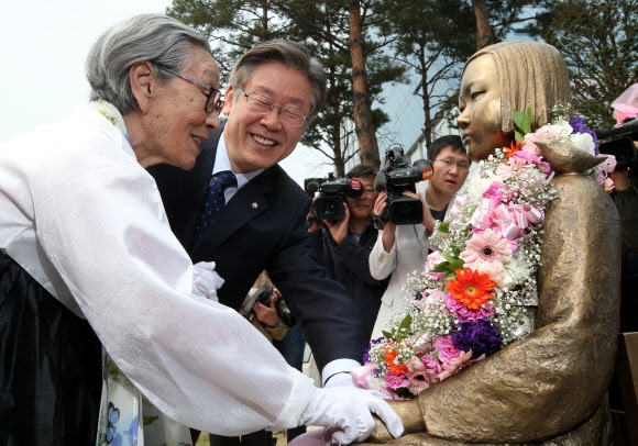 15일 경기 성남시 중원구 여수동 성남시청 광장에 세워진 일본군 위안부 피해자를 기리는 ‘평화의 소녀상’을 위안부 강제 동원의 산 증인 김복동(왼쪽) 할머니가 이재명 성남시장과 함께 어루만지고 있다. 연합뉴스 