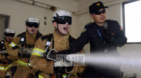 방수훈련. 2~3명씩 조를 이뤄 호스를 꺼내 길게 펼친 뒤 호스 입구 관창을 돌려 물의 세기를 조절하며 물을 뿌려야 한다.