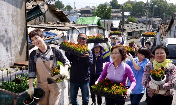 재개발 예정 지역인 경기 부천시 계수동에서 금미정(앞줄 왼쪽)씨 등 게릴라 가드너들이 자투리땅과 인적이 드문 골목길의 쓰레기를 치우고 그 자리를 화단으로 가꾸는 ‘게릴라 가드닝’ 활동을 벌이고 있다.