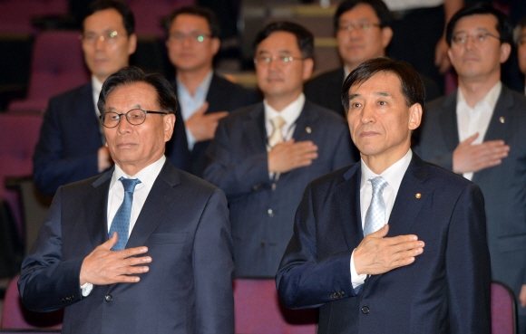 12일 서울 중구 남대문로 한국은행 별관에서 열린 제64회 한국은행 창립기념일 행사에서 이주열(앞줄 오른쪽) 한은 총재가 국기에 대한 경례를 하고 있다. 앞줄 왼쪽은 하성근 금융통화위원.