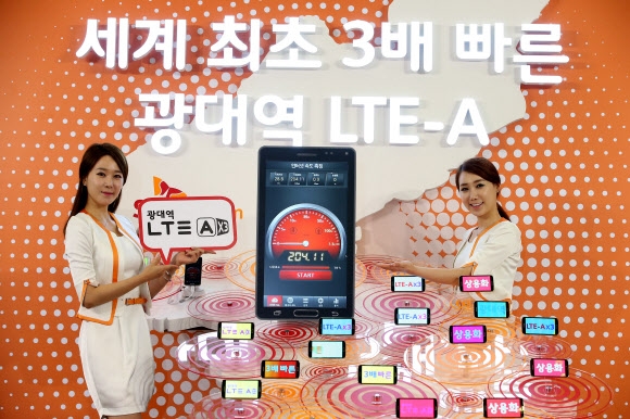 SK텔레콤은 19일 기존 LTE 보다 3배 빠른 ‘225Mbps 광대역 LTE-A’ 서비스를 세계최초로 상용화했다. 이날 오전 모델들이 서울 중구 을지로 T타워에서  ‘광대역 LTE-A 서비스’의 개시를 알리는 한반도 구조물과 단말기를 배경으로 포즈를 취하고 있다. 연합뉴스