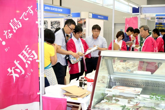 2일 부산 해운대구 벡스코에서 열린 ’2014 부산국제수산무역엑스포’에서 관람객들이 일본 대마도 수산물 요리를 시식하고 있다. 30개국에서 354개사가 참여한 이 행사에는 씨푸드관, 수산기자재관, 해양바이오관이 마련된다. 주제별 테마관은 고등어 홍보관, 신제품 홍보관, 낚시용품 특별관, 부산어묵 특별관으로 구성된다. 연합뉴스