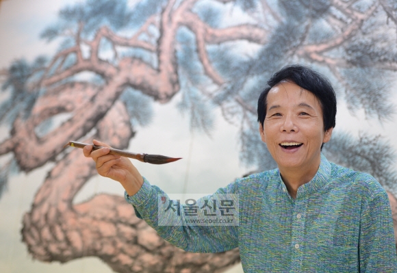 지난달 25일 서울 종로구 필운동 작업실에서 만난 이영복 화백이 ‘쌍룡송’ 그림을 배경으로 붓을 들고 환하게 웃고 있다. 이언탁 기자 utl@seoul.co.kr