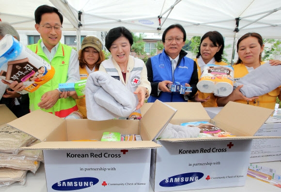 박근희 삼성사회봉사단 부회장(오른쪽 세번째)이 7일 오전 서울 양천구 신월동 대한적십자사 긴급구호종합센터에서 유중근 대한적십자사 총재(오른쪽 네번째)와 함께 지진, 태풍, 쓰나미 등으로 피해를 본 이재민에게 보낼 국제 긴급구호품을 상자에 담고 있다. 연합뉴스
