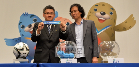21일 인천 중구 하버파크호텔에서 열린 인천아시안게임 단체·구기종목 조 추첨에서 최순호(오른쪽) 대한축구협회 부회장이 대회 조직위 관계자와 함께 축구 조 추첨을 하고 있다. 손형준 기자 boltagoo@seoul.co.kr