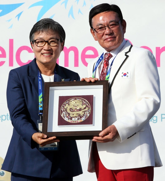 2014 인천 아시안게임 개막을 하루 앞둔 18일 인천 남동구 선수촌 국기광장에서 열린 한국선수단 입촌식에서 박순호 한국선수단장(오른쪽)이 이에리사 선수촌장에게 기념품을 전달하고 있다. 연합뉴스