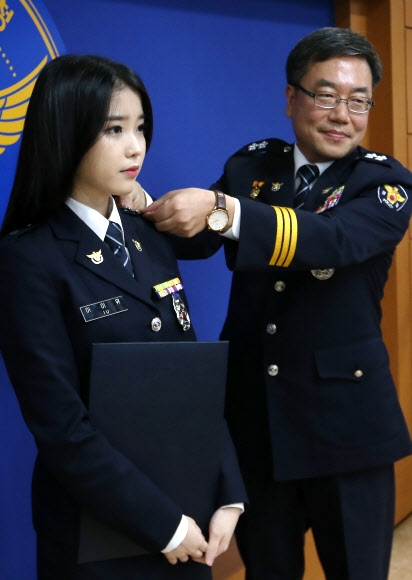 6일 경찰청에서 열린 ‘명예경찰 특별승진 임용식’에서 명예 경장으로 승진한 가수 아이유(왼쪽)에게 서범수 경찰청 생활안전국장이 계급장을 달아 주고 있다. 연합뉴스