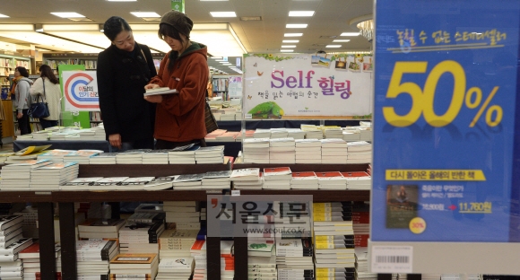 도서정가제 시행(21일)을 앞둔 가운데 12일 서울시내 한 대형서점을 찾은 시민들이 할인코너에서 책을 고르고 있다. 손형준 기자 boltagoo@seoul.co.kr