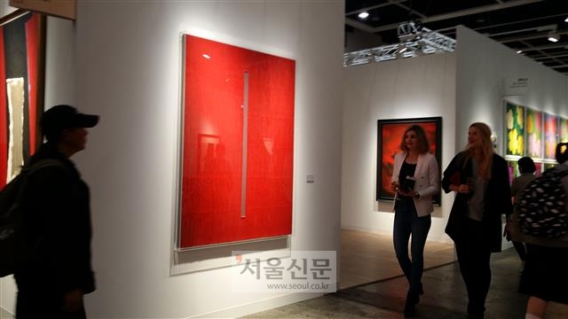 드 사르트 갤러리에서 출품한 박서보 화백의 작품 ‘묘법’ 앞을 관람객들이 지나가고 있다.