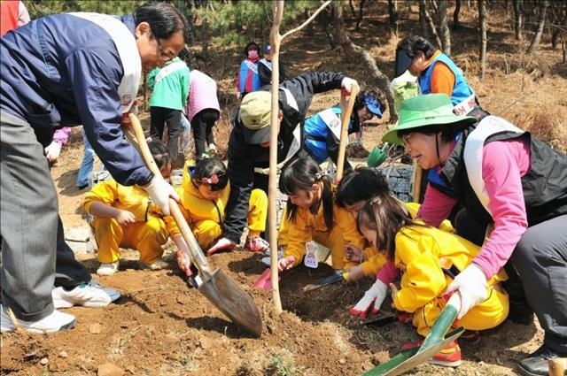 아이들이 식목일을 맞아 야산에 묘목을 심고 있다. 지구온난화에 따라 기온이 상승하면서 식목일을 앞당겨야 한다는 주장이 나오고 있다. 국립산림과학원 제공