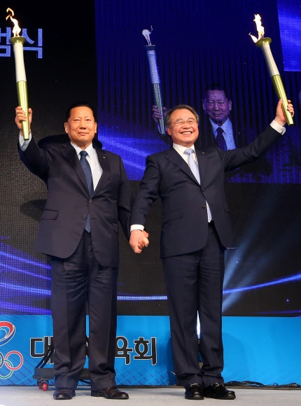 통합대한체육회의 김정행(왼쪽)·강영중 공동 회장이 8일 서울 송파구 올림픽파크텔에서 진행된 통합 출범식 및 비전 선포식에서 함께 성화를 들어 보이는 비전 퍼포먼스를 하고 있다. 연합뉴스