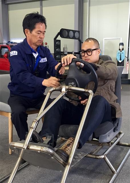 핸들은 3시 9시 방향에 강신(오른쪽) 기자가 지난 7일 한국교통안전교육센터에서 황운기 원장으로부터 운전 자세를 교정받고 있다. 한국교통안전교육센터 제공