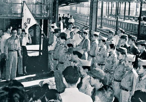 태극기를 앞세우고 출정식을 갖고 있는 재일동포 학도의용군. 1950년 6월 25일 한국전쟁이 나자 일본에서 공부하고 일하던 민단 소속 재일 한국 학생 및 청년 642명이 자원 참전했다. 135명이 전사했다. 재일본대한민국민단 제공
