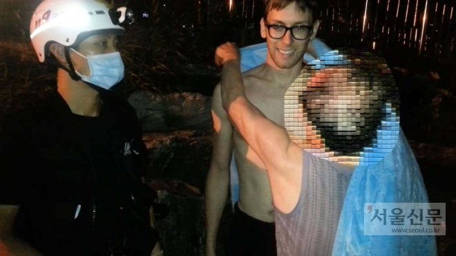부산 수영강에 투신한 A씨가 자신을 구해준 플레이크 모리 존에게 119구조대원이 준 자신의 담요를 덮어주고 있다.