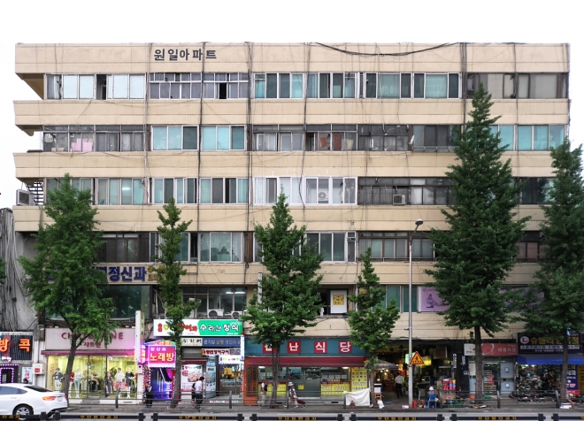 원일 아파트의 정면. 전형적인 근대건축의 무뚝뚝한 디자인이지만 자세히 보면 섬세한 디테일이 있다. 시장으로 들어가는 입구가 보인다. 건축가 황두진 제공