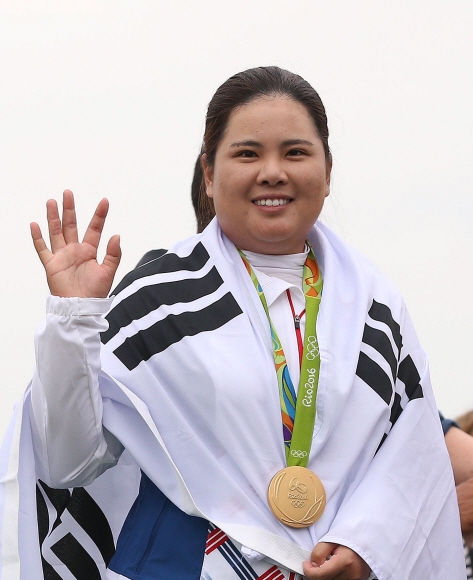 리우올림픽 여자골프에서 금메달을 딴 박인비가 21일(한국시간) 브라질 리우데자네이루 올림픽 골프경기장에서 열린 시상식에서 태극기를 몸에 두르고 손을 흔들며 인사하고 있다. 리우데자네이루 올림픽사진공동취재단