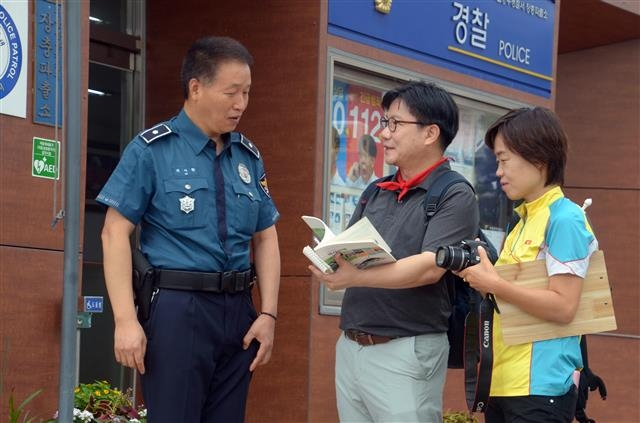 장충단 옆에 있는 장충단파출소 위시환(왼쪽) 경위는 지역 치안과 문화재 보호 활동을 겸하고 있다고 자신을 소개했다. 위 경위가 건네준 서울 중부경찰서가 펴낸 ‘서중경의 역사산책’을 받아 든 유성호(가운데) 문화지평 대표, 이날 보조 진행을 맡은 손안나 서울미래유산해설사.