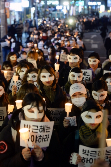 15일 저녁 서울 서대문구 창천문화공원에서 열린 ‘박근혜 대통령 퇴진 촉구 집회’에서 대학생들이 가면을 쓴 채 촛불과 피켓을 들고 행진하고 있다. 강성남 선임기자 snk@seoul.co.kr