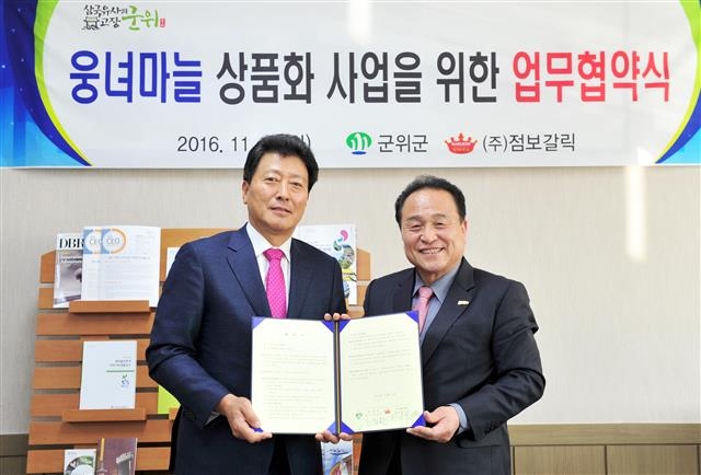 김영만(오른쪽) 군위군수와 한진우 ㈜점보갈릭 대표가 양해각서(MOU)’를 체결한 뒤 기념사진을 찍고 있다. 군위군 제공