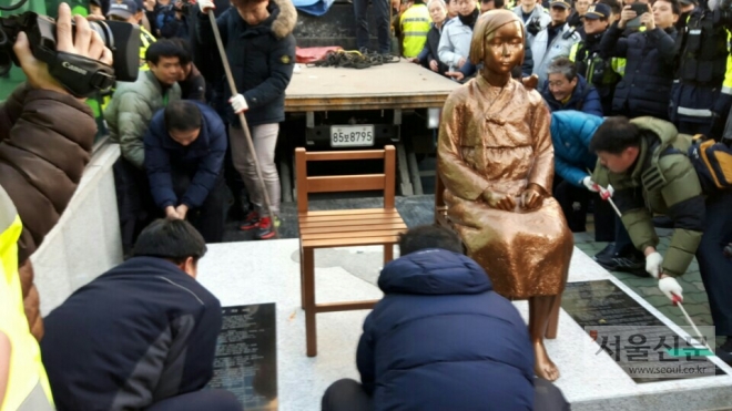 한일 정부의 위안부 합의 1주년인 28일 부산 동구 초량동 일본영사관 후문 앞에 시민단체 회원들이 기습 설치한 소녀상을 경찰과 동구청 관계자들이 트럭에 싣고 있다.