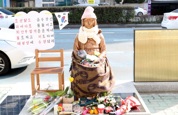 9일 부산 동구 초량동 일본영사관 앞에 있는 평화의 소녀상 주변에 시민이 두고 간 꽃다발 등이 쌓여 있다. 한일 위안부 합의를 비판하는 글과 태극기도 보인다. 연합뉴스