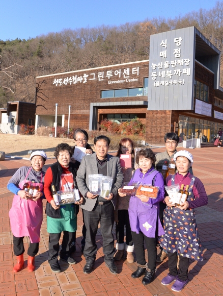 박성기(앞줄 가운데) ‘청도 성수월마을 영농조합법인’ 위원장과 직원들이 경북 청도군 ‘그린 투어 센터’ 건물 앞에서 지역 특산품을 소개하고 있다. 청도 최해국 선임기자 seaworld@seoul.co.kr