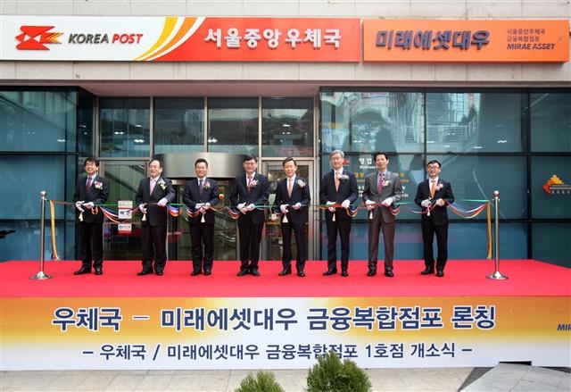 13일 서울 중구 소공로 서울중앙우체국 앞에서 열린 금융복합점포 개점 기념식에서 정진용(왼쪽 네 번째) 우정사업본부 예금사업단장과 최현만(다섯 번째) 미래에셋대우 대표이사 등이 기념 테이프를 자르고 있다.