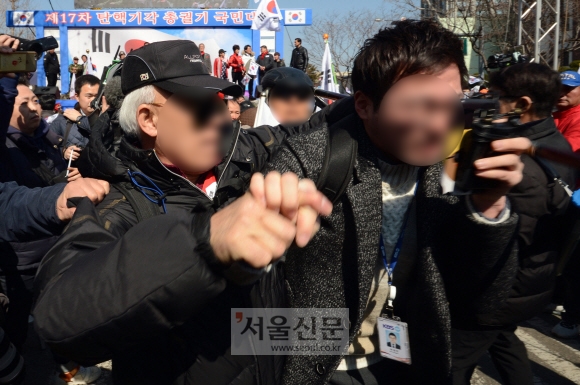 10일 서울 헌법재판소 앞 안국역에서 보수단체 회원이 탄핵이 인용되자 흥분한 상태로 기자를 폭행하고 있다. 박지환 기자 popocar@seoul.co.kr