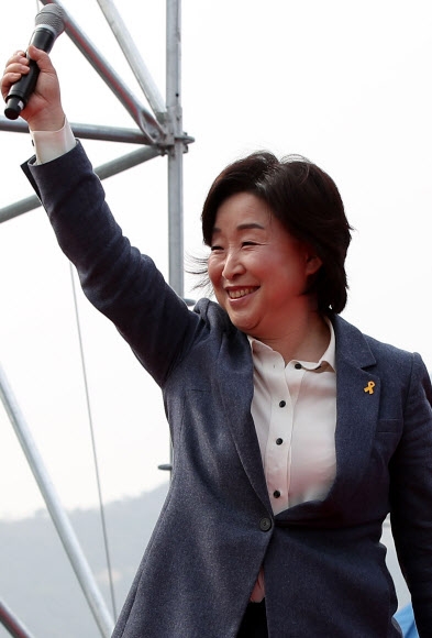 심상정 정의당 대선 후보가 지난 8일 광화문광장에서 열린 공공노동자대회에서 참석자들을 향해 마이크를 쥔 손을 들며 미소 짓고 있다. 연합뉴스