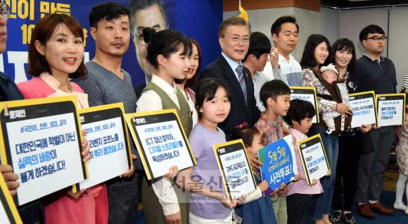 문재인 대통령은 선거운동 기간에 최저임금 1만원 보장, 세월호 기간제 교사의 순직 인정, 고교 서열화 방지를 위한 특목고의 일반고 전환 등을 담은 ‘국민이 만든 10대 공약’을 발표했다. 사진은 지난 5일 서울 여의도 더불어민주당 당사에서 시민들과 함께 10대 공약 손팻말을 들고 있는 모습. 이종원 선임기자 jongwon@seoul.co.kr