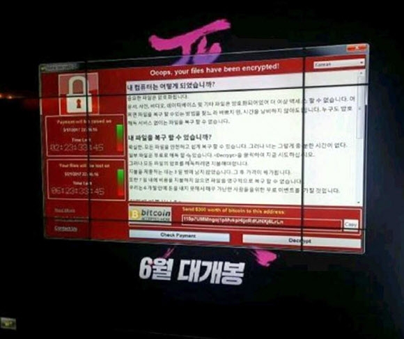 피해 기업 중 한 곳인 CJ CGV의 상영관 내 스크린에 ‘문제를 해결하려면 돈을 지불하라’는 내용의 협박 메시지가 떠 있다. 연합뉴스