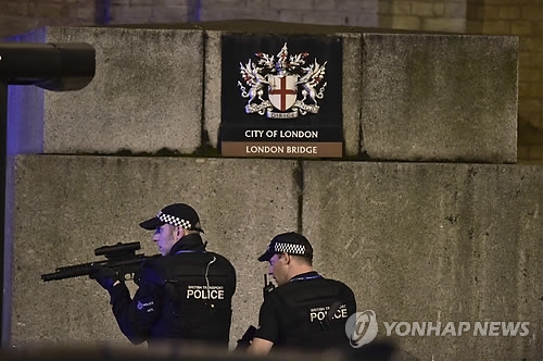 3일(현지시간) 밤 차량 돌진 테러 발생한 영국 런던 시내 런던 브리지에서 수색작업을 벌이는 무장 경찰[AP=연합뉴스]