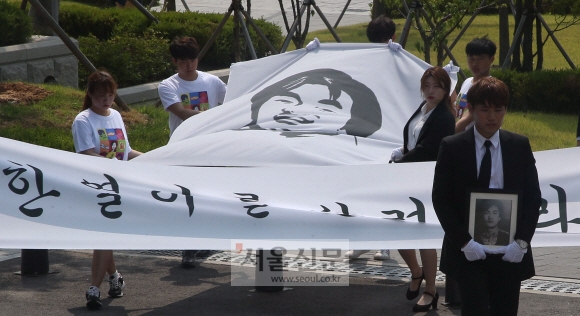 ’故 이한열 열사 30주기 추모제’가 열린 9일 오후 서울 서대문구 연세대학교 정문 앞에서 재학생들이 이한열 열사의 영정을 들고 한열동산으로 이동하고 있다. 박지환 기자 popocar@seoul.co.kr