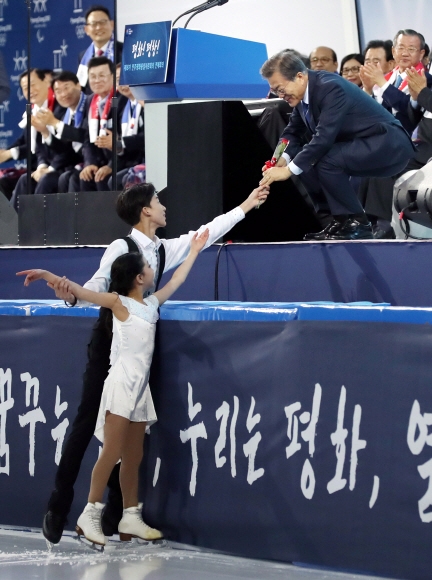 문재인 대통령이 31일 오후 강원도 강릉 교동 강릉 아이스아레나에서 열린 평창 동계올림픽 성공을 기원하는 공연에서 피겨 선수단에게 장미꽃을 받고 있다. 안주영 기자 jya@seoul.co.kr