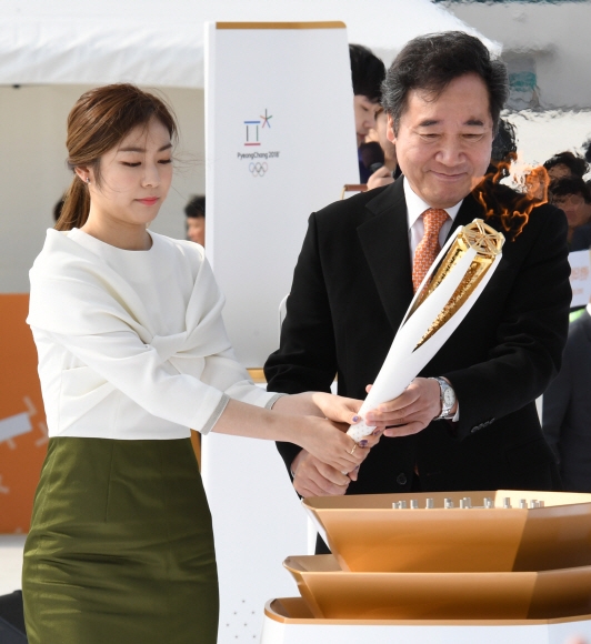 이낙연(오른쪽) 국무총리와 2018 평창동계올림픽 홍보대사인 김연아가 1일 인천국제공항 제2여객터미널에 마련된 임시 성화대에 불꽃을 점화하고 있다. 성화는 이날부터 101일 동안 17개 시·도 2018㎞ 구간을 이어 달리는 봉송 일정에 들어갔다. 박윤슬 기자 seul@seoul.co.kr
