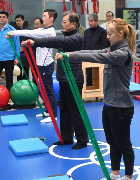 문재인 대통령이 17일 오후 충청북도 진천군 진천 국가대표 선수촌을 방문, 메디컬센터에서 스피드스케이팅 김보름 선수와 밴드를 이용한 근력 강화 운동 동작을 따라 하고 있다.  청와대사진기자단