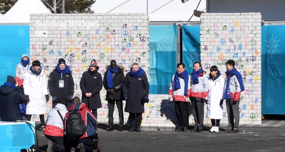 토마스 바흐(오른쪽 다섯 번째) 국제올림픽위원회(IOC) 위원장과 이희범(네 번째) 평창조직위원회 위원장 등이 5일 강원 평창선수촌에서 제막된 ‘휴전벽’ 앞에서 기념 촬영을 하고 있다. 휴전벽은 대회 기간 내내 평화를 염원하는 선수들의 서명으로 장식된다. 평창 박지환 기자 popocar@seoul.co.kr