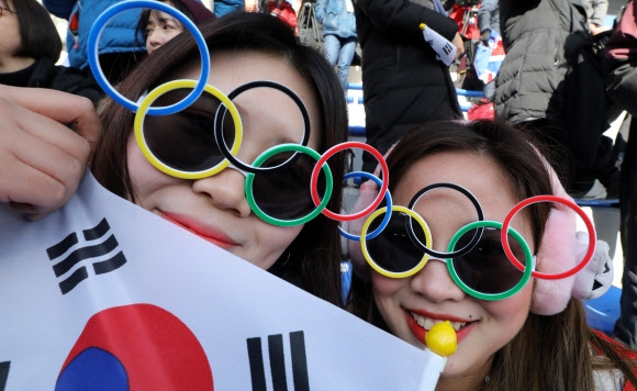 윤성빈이 금메달을 목에 건 지난 16일 스켈레톤 남자 경기가 열린 평창 슬라이딩센터를 찾은 시민들이 오륜기 선글라스를 쓰고 응원을 벌이고 있다. 연합뉴스