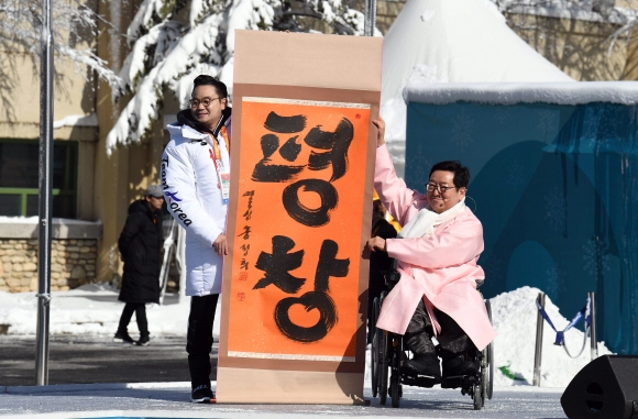 2018 평창동계패럴림픽 개막을 사흘 앞둔 6일 오전 강원도 평창선수촌에서 열린 선수단 입촌식에서 박은수 선수촌장(오른쪽)이 붓글씨로 평창이라고 적힌 응원 문구를 들고 기념촬영을 하고 있다. 박윤슬 기자 seul@seoul.co.kr