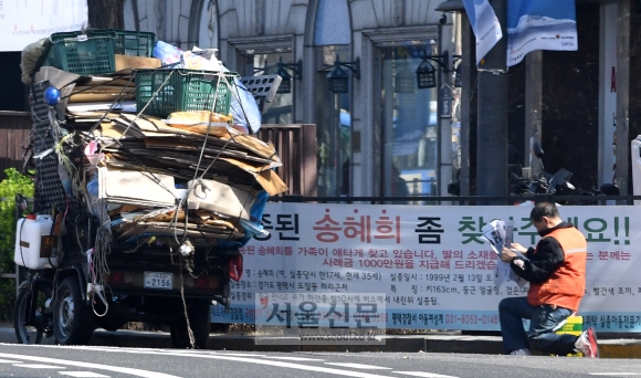 신문 보는 폐지 줍는 노인
