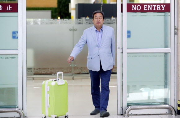 일본에서 귀국한 김무성 당시 바른정당 의원이 김포공항 입국장에서 마중 나온 관계자에게 캐리어를 밀어 전달하고 있다. 2017.5.23 서울신문 DB