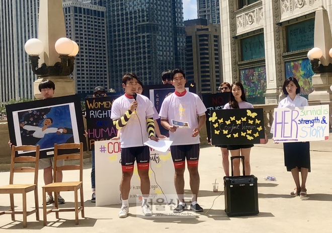 일본군 위안부 문제를 알리기 위해 미대륙 자전거 횡단에 나선 ‘3A(트리플 에이) 프로젝트’ 4기 멤버 백현재(25·백석대, 좌) 이호준(22·인천대, 우)씨가 지난 2일 시카고 소재 리글리 빌딩 앞에서 수요집회를 진행하고 있다. (사진제공=백현재, 이호준) 일본군 위안부 문제를 알리기 위해 미대륙 자전거 횡단에 나선 ‘3A(트리플 에이) 프로젝트’ 4기 멤버 백현재(25·백석대, 좌) 이호준(22·인천대, 우)씨가 지난 2일 시카고 소재 리글리 빌딩 앞에서 수요집회를 진행하고 있다. (사진제공=백현재, 이호준)